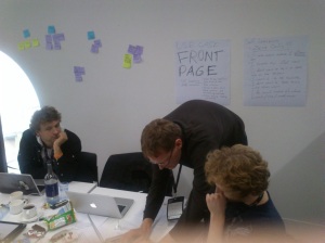 PostIt Notes on the wall behind developers conferring